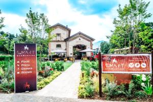 un bâtiment avec des panneaux en face d'un jardin dans l'établissement SMART San Martino, à Paratico