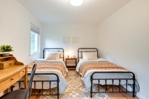 Glen Cove Vacation Rental Less Than 1 Mi to Downtown! في Glen Cove: سريرين في غرفة بجدران بيضاء