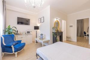 Un dormitorio blanco con una silla azul y una cama en CRYS: Apartments, Holiday, Business, Blu, en Verona