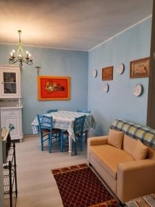 un soggiorno con tavolo e divano di Appartamento Azzurro a Torre Grande