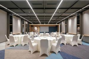 a conference room with white tables and white chairs at ibis Surabaya Tidar in Surabaya