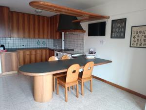 una cocina con mesa y algunas sillas. en Casa Vacanze Lavanda & Rosmarino, en Telve