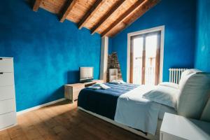a blue bedroom with a bed and a television at Casa Genziana - Lakeside Leisure & Business in Vezzo
