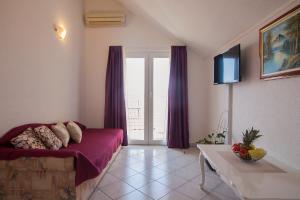 a living room with a purple couch and a table at Aurora Apartments in Bol