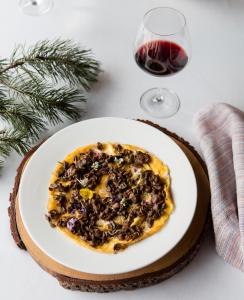 una rebanada de pizza en un plato con una copa de vino en Acta Arthotel, en Andorra la Vella