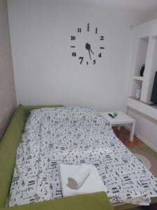 1 dormitorio con 1 cama con reloj en la pared en Apartman Stil, en Višegrad