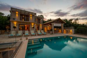 uma casa com piscina em frente a uma casa em Villa Ozias a modern,spacious, swimmig pool villa. em Gaios