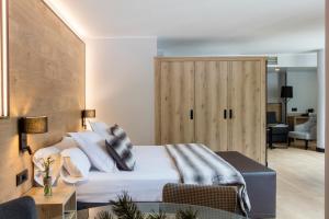 1 dormitorio con 1 cama y puerta de madera en Acta Arthotel, en Andorra la Vella