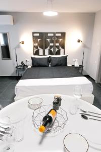 a bedroom with a bed with a bottle of wine on a table at Venizelou Comfort & Living II in Kavala