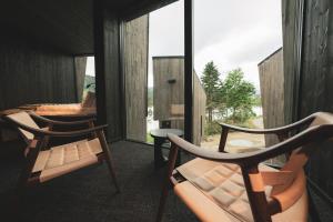 Duas cadeiras e uma cama num quarto com janelas em Elva Hotel em Skulestadmo