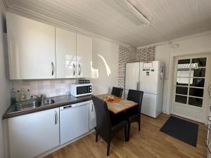 a kitchen with a table and a white refrigerator at Oslo House, Nedre Kjellerstuvei, First floor, Twin Room in Lillestrøm