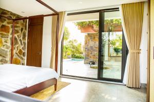 a bedroom with a bed and a sliding glass door at An Sunrise Villa Vinh Phuc in Vĩnh Phúc