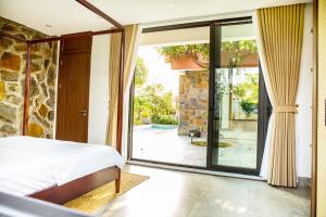 Vĩnh PhúcにあるAn Sunrise Villa Vinh Phucのベッドとガラスの引き戸のある寝室 +33枚の写真