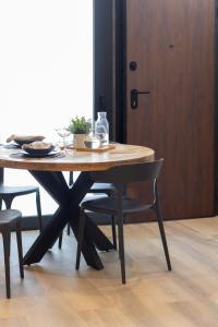 uma mesa de madeira com 2 cadeiras e uma porta de madeira em VLC Host - Vels i Mar em Valência