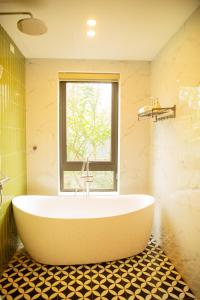 a bath tub in a bathroom with a window at An Sunrise Villa Vinh Phuc in Vĩnh Phúc