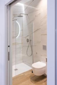 uma casa de banho com um WC e uma cabina de duche em vidro. em VLC Host - Vels i Mar em Valência