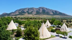 un grupo de tiendas de campaña con una montaña en el fondo en Casa Bella Teepees, en Zújar