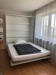Una cama con una manta negra en un dormitorio en Appartement Stuttgart Messe & Flughafen, en Leinfelden-Echterdingen
