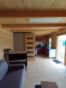 a living room with a couch and a kitchen at Tiny house toute équipée avec jardin in Saint-Florent-sur-Cher