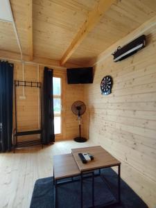 a living room with a table in a wooden room at Tiny house toute équipée avec jardin in Saint-Florent-sur-Cher