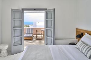 a bedroom with a bed and a view of the ocean at Vedema, a Luxury Collection Resort, Santorini in Megalokhori