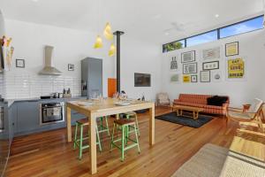 a kitchen and living room with a table and chairs at Hannah's Bay Hideaway in Rotorua