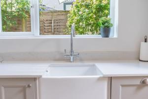 eine Küchentheke mit einem Waschbecken und einem Fenster in der Unterkunft Hazelgrove, Ratcliffe Place, Keswick in Keswick