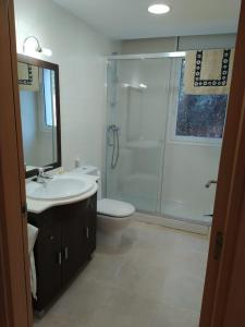 ein Bad mit einer Dusche, einem Waschbecken und einem WC in der Unterkunft Luminoso y amplio apartamento con piscina in Llança