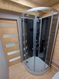 a glass shower in a room with two doors at Tiny house toute équipée avec jardin in Saint-Florent-sur-Cher