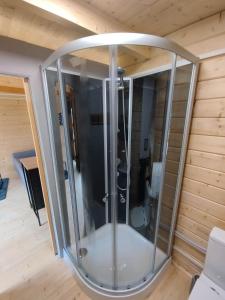 a glass shower in a room with a ceiling at Tiny house toute équipée avec jardin in Saint-Florent-sur-Cher