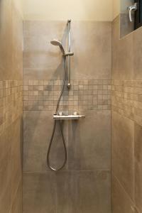 a shower with a shower head in a bathroom at De Slaaperij in Wilbertoord