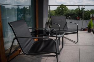 2 sillas negras sentadas en un balcón en Turkusowe tarasy apartament, en Czeladź