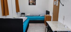 a small room with a blue bed and a tv at The Hostel in Hamburg