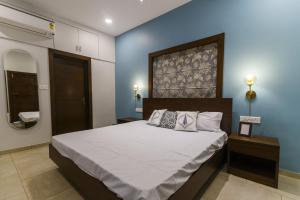 una camera con un grande letto e una parete blu di Eerus Villa 3Bhk Luxurious Home ad Arpora
