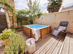 einen Pool auf einer Holzterrasse mit einem Stuhl und einem Tisch in der Unterkunft Sublime maison charentaise in Jarnac