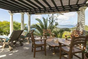 a group of chairs and tables on a patio at Arc Du Soleil- 3 BDRM Sleeps 6 Stunning Views in Cruz Bay