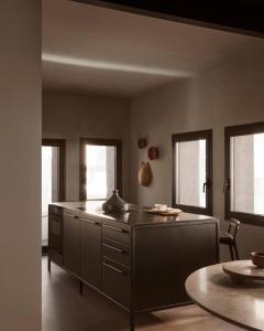 een keuken met een aanrecht en een tafel en ramen bij casa vipp in Andorra la Vella