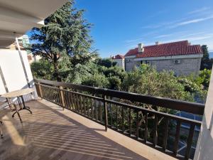 einen Balkon mit einer Bank und Bäumen sowie ein Gebäude in der Unterkunft Victoria Apartments in Makarska