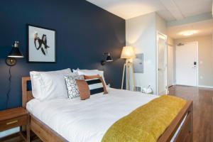 サンフランシスコにあるSoMa Studio w Gym Rooftop Lounge nr Tech HQs SFO-94の青い壁と大きな白いベッドのある寝室 +13枚の写真