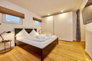 um quarto com uma cama com um candeeiro e uma televisão em BergIdylle 1 em Garmisch-Partenkirchen