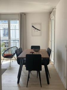 a dining room with a wooden table and chairs at Élégance et Confort entre Disney et Val d'Europe 6 Personnes+Parking in Serris +13 photos