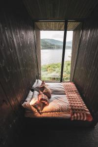 a person laying on a bed in a room with a window at Elva Hotel in Skulestadmo