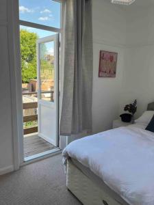 a bedroom with a bed and a sliding glass door at Flat Beside the sea in Southend-on-Sea