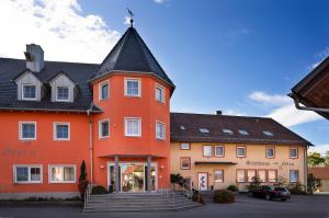 um grande edifício laranja com um telhado preto em Gasthaus zum Stern em Gollhofen