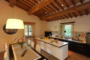 a large kitchen with a table and a counter top at Villa Costa piccola with private pool in Umbria in Umbertide