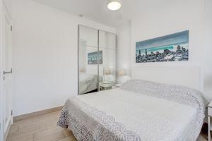 a white bedroom with a bed and a mirror at CLUB PARAISO 1a085 in Playa Paraiso