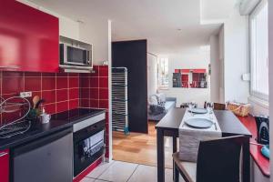 een keuken met rode muren en een aanrecht bij Studio cosy proche centre-ville et gare in Mulhouse