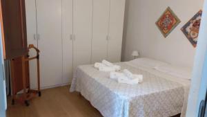 A Casa di Clara في تراباني: غرفة صغيرة بسريرين وطاولة بها شراشف بيضاء