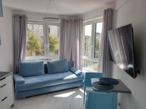 sala de estar con sofá azul y ventana en Apartamenty MorzeLove, en Rowy