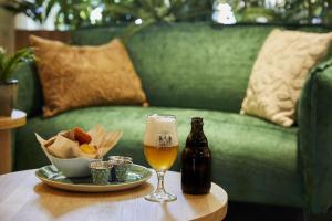 una mesa con un vaso de cerveza y un plato de comida en Park Eksel en Hechtel-Eksel